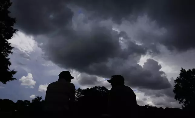 Fans wait for play to resume during a weather delay at a practice round for the PGA Championship golf tournament at the Quail Hollow Club, Tuesday, May 13, 2025, in Charlotte, N.C. (AP Photo/George Walker IV)