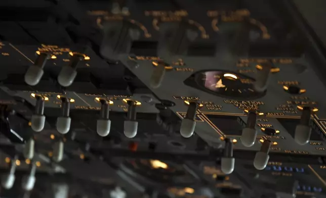 Switches in the cockpit of a United Airlines flight simulator are lit up at the company's training campus in Denver, Friday, May 16, 2025. (AP Photo/Thomas Peipert)