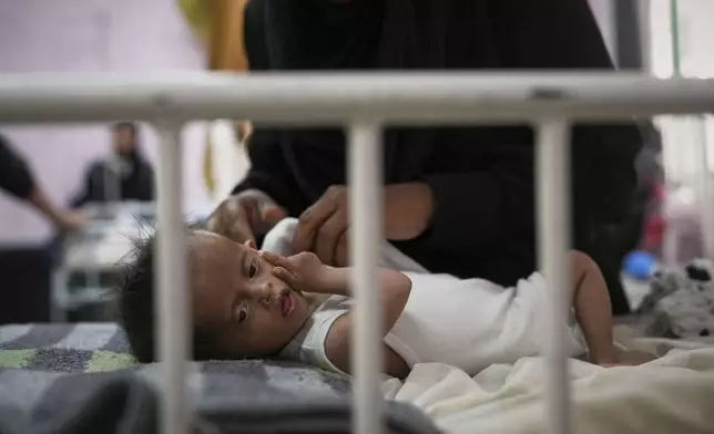 Rahma al-Qadi takes care for her 7-month-old daughter Sama, who was born with Down syndrome and suffers from malnutrition, at the malnutrition clinic in Nasser hospital, Khan Younis, Gaza, Thursday, May 1, 2025. (AP Photo/Abdel Kareem Hana)