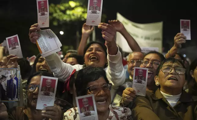 People celebrate waving flyers of newly-elected Pope Leo XIV during a Mass in his honor, in Chiclayo, Peru, Saturday, May 10, 2025. (AP Photo/Guadalupe Pardo)