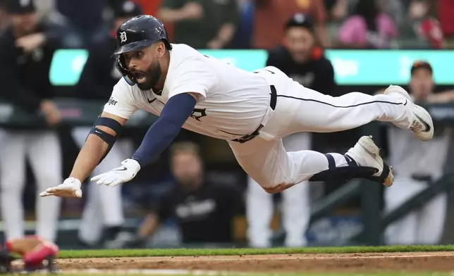 Detroit Tigers' Riley Greene dives safely into home plate against the Boston Red Sox in the third inning during a baseball game, Monday, May 12, 2025, in Detroit. (AP Photo/Paul Sancya)