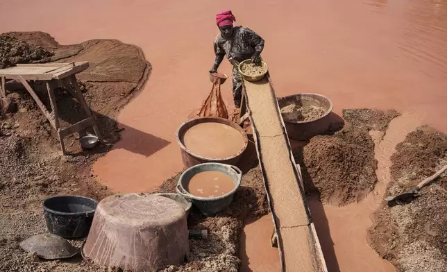 A woman processes gold at a mining site in the Kedougou region of Senegal on Thursday, Jan. 16, 2025. (AP Photo/Annika Hammerschlag)