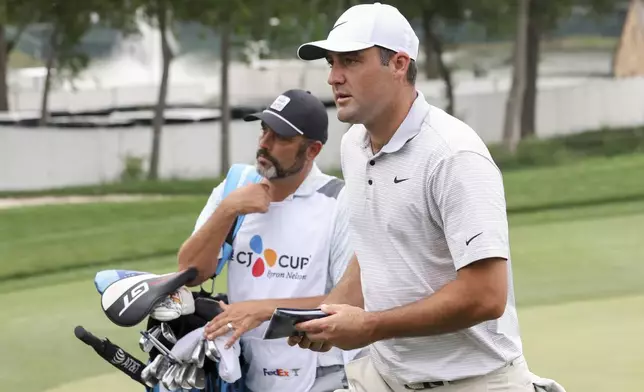 Scottie Scheffler, right, walks on the 18th fairway during the first round of the CJ Cup Byron Nelson golf tournament in McKinney, Texas, Thursday, May 1, 2025. (AP Photo/Gareth Patterson)