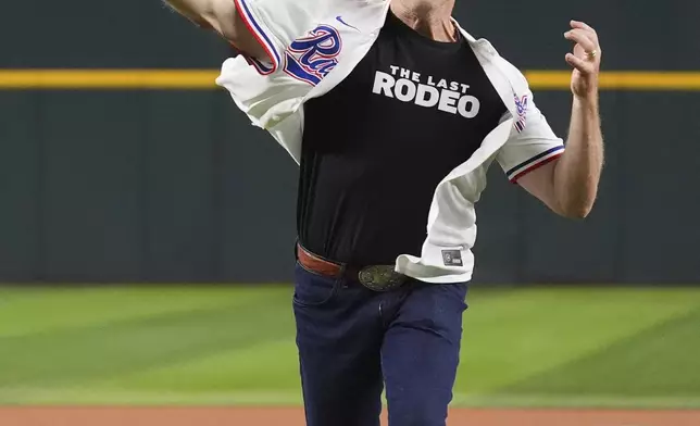 Actor Neal McDonough throws the first pitch of a baseball game between the Colorado Rockies and Texas Rangers, Wednesday, May 14, 2025, in Arlington, Texas. (AP Photo/LM Otero)