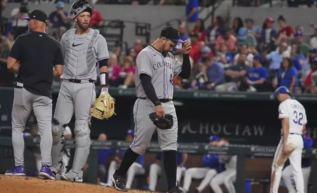 Colorado Rockies starting pitcher Antonio Senzatela, right, leaves play as interim manager Warren Schaeffer, left, and catcher Jacob Stallings stand on the mound during the fifth inning of a baseball game against the Texas Rangers, Wednesday, May 14, 2025, in Arlington, Texas. (AP Photo/LM Otero)