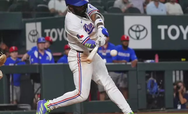 Texas Rangers' Adolis García hits a home run during the sixth inning of a baseball game against the Colorado Rockies, Wednesday, May 14, 2025, in Arlington, Texas. (AP Photo/LM Otero)
