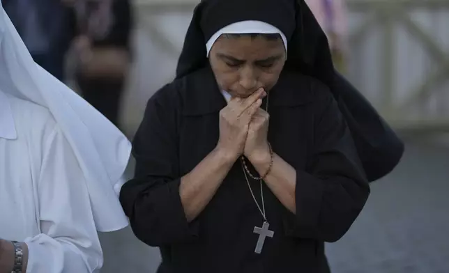 Sor Clara a nun from Peru prays during the speech of the newly elected Pope Leo XIV at the Vatican, Thursday, May 8, 2025. (AP Photo/Francisco Seco)