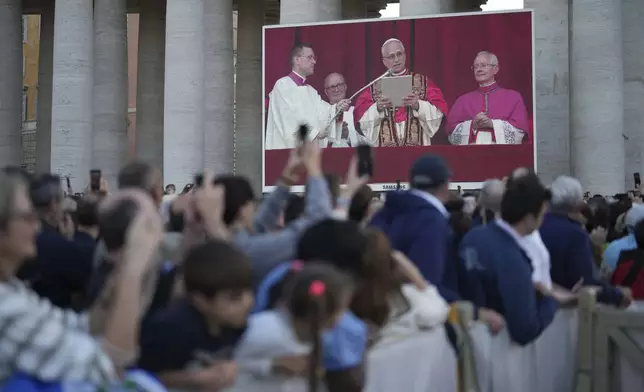 Faithful listen the speech of the newly elected Pope Leo XIV at the Vatican, Thursday, May 8, 2025. (AP Photo/Francisco Seco)