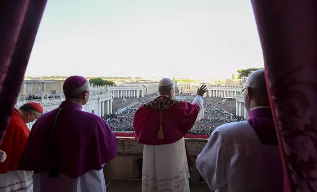Newly elected Pope Leo XIV waves to faithful and pilgrims gathered in St. Peter's Square at the Vatican shortly after his election, Thursday, May 8, 2025. (Vatican Media via AP)