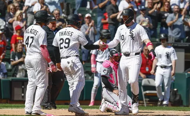 Chicago White Sox's Tim Elko, right, celebrates with Matt Thaiss (29) and Joshua Palacios, left, after hitting a three-run home run against the Miami Marlins during the sixth inning of a baseball game Sunday, May 11, 2025, in Chicago. (AP Photo/Kamil Krzaczynski)