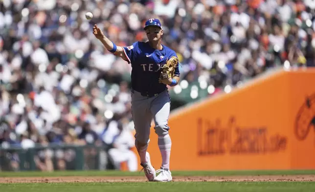 Texas Rangers third baseman Josh Jung throws to first base for an out on a Detroit Tigers' Zach McKinstry ground ball in the second inning during a baseball game, Sunday, May 11, 2025, in Detroit. (AP Photo/Paul Sancya)