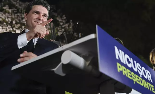 Presidential candidate Nicusor Dan gestures as he addresses supporters after polls closed for the first round of the country's presidential election redo in Bucharest, Romania, Sunday, May 4, 2025. (AP Photo/Eduard Vinatoru)