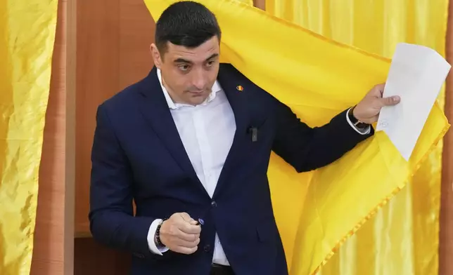 Presidential candidate George Simion exits a voting cabin before casting his vote in the first round of the presidential election redo in Mogosoaia, Romania, Sunday, May 4, 2025. (AP Photo/Vadim Ghirda)