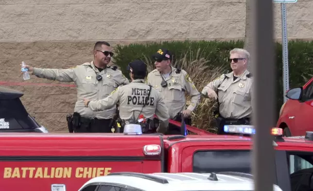 Las Vegas Metro Police officers confer by the main entrance of a Las Vegas Athletic Club after a shooting Friday, May 16, 2025, in Las Vegas. (Steve Marcus/Las Vegas Sun via AP)