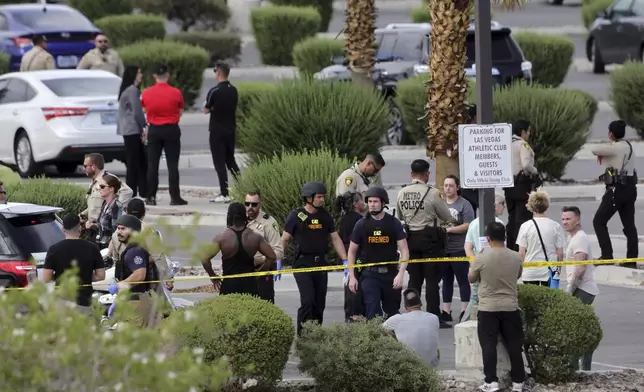 Las Vegas Metro Police officers talk with gym members after a shooting at a Las Vegas Athletic Club Friday, May 16, 2025, in Las Vegas. (Steve Marcus/Las Vegas Sun via AP)