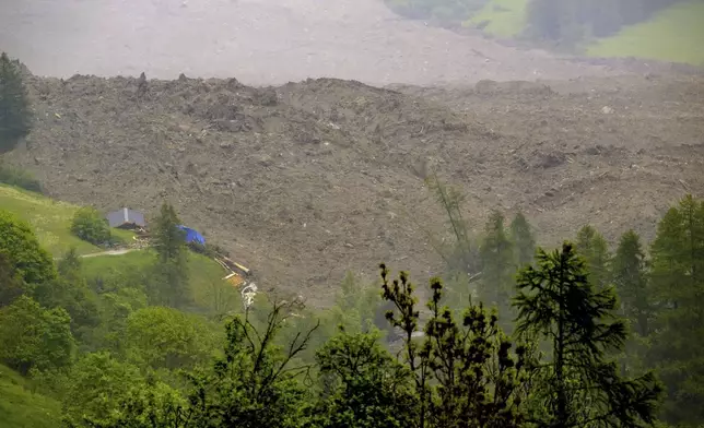 A large avalanche with a mixture of ice, rock, snow and water reach the valley floor is pictured in Wiler after the Birch glacier collapsing above Blatten, Switzerland, Wednesday, May 28, 2025. (Jean-Christophe Bott/Keystone via AP)