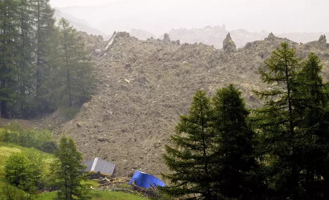 A large avalanche with a mixture of ice, rock, snow and water reach the valley floor is pictured in Wiler after the Birch glacier collapsing above Blatten, Switzerland, Wednesday, May 28, 2025. (Jean-Christophe Bott/Keystone via AP)
