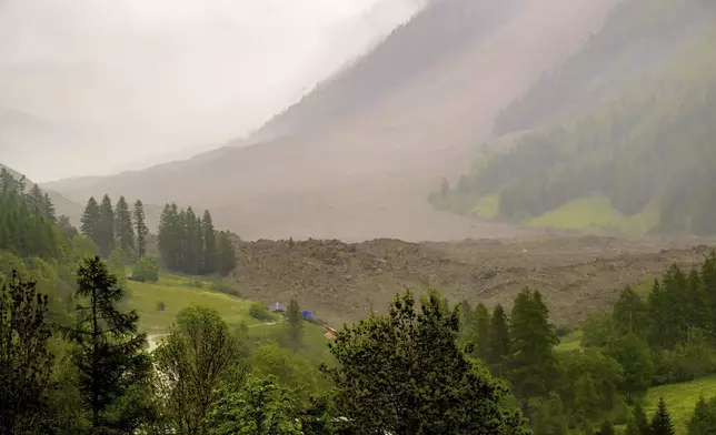 A large avalanche with a mixture of ice, rock, snow and water reach the valley floor is pictured in Wiler after the Birch glacier collapsing above Blatten, Switzerland, Wednesday, May 28, 2025. (Jean-Christophe Bott/Keystone via AP)