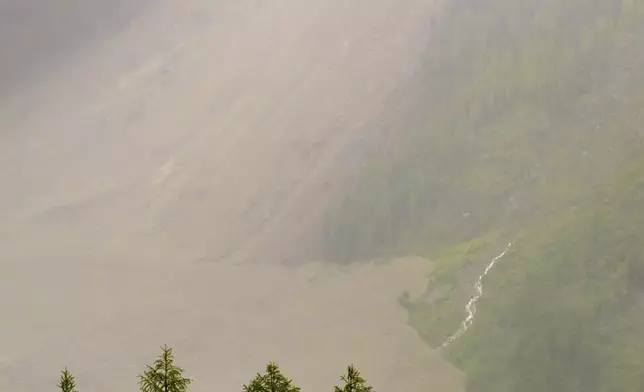 A large avalanche with a mixture of ice, rock, snow and water reach the valley floor is pictured in Wiler after the Birch glacier collapsing above Blatten, Switzerland, Wednesday, May 28, 2025. (Jean-Christophe Bott/Keystone via AP)
