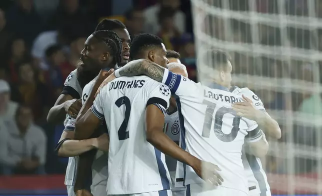 Inter Milan's Marcus Thuram, left, celebrates with his teammates after scoring his side's opening goal during the Champions League semifinal first leg soccer match between Barcelona and Inter Milan at the Lluis Companys Olympic Stadium in Barcelona, Spain, Wednesday, April 30, 2025. (AP Photo/Joan Monfort)