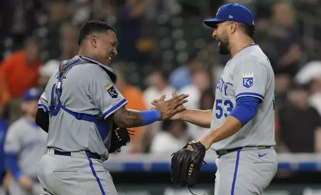 Kansas City Royals catcher Salvador Perez, left, and relief pitcher Carlos Estevez celebrate after winning a baseball game against the Houston Astros in Houston, Monday, May 12, 2025. (AP Photo/Ashley Landis)