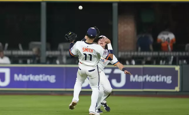 Houston Astros center fielder Jake Meyers, right, nearly collides with right fielder Cam Smith (11) catches a fly ball hit by Kansas City Royals' Maikel Garcia during the ninth inning of a baseball game in Houston, Monday, May 12, 2025. (AP Photo/Ashley Landis)