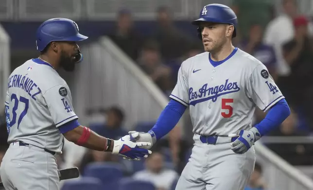 Los Angeles Dodgers' Freddie Freeman (5) celebrates a two-run home run with Teoscar Hernández (37) during the third inning of a baseball game against the Miami Marlins, Monday, May 5, 2025, in Miami. (AP Photo/Marta Lavandier)