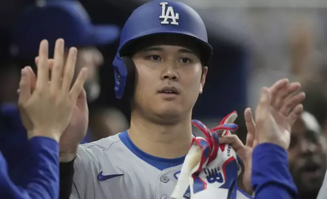 Los Angeles Dodgers' Shohei Ohtani celebrates after scoring on a home run by Freddie Freeman during the third inning of a baseball game against the Miami Marlins, Monday, May 5, 2025, in Miami. (AP Photo/Marta Lavandier)