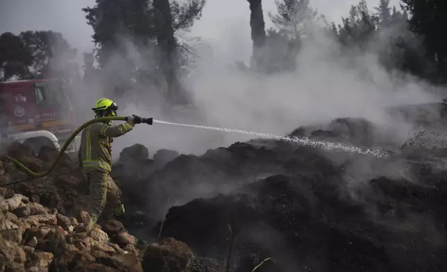 An Israeli firefighter battles a wildfire near Latrun, Israel, outside of Jerusalem, Thursday, May 1, 2025. (AP Photo/Ohad Zwigenberg)