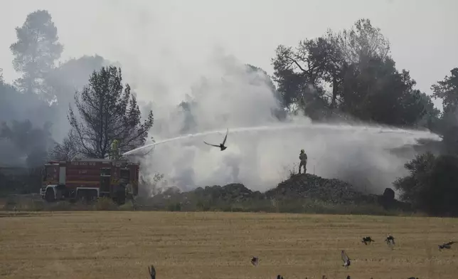 An Israeli crew battles a wild fire near Latrun, Israel, outside of Jerusalem Thursday, May 1, 2025. (AP Photo/Ohad Zwigenberg)