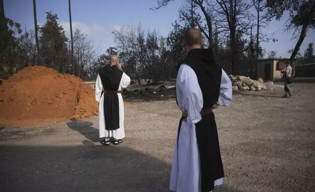 Roman Catholic Trappist monks take in the scene near a wildfire in Latrun, Israel, outside of Jerusalem Thursday, May 1, 2025. (AP Photo/Ohad Zwigenberg)