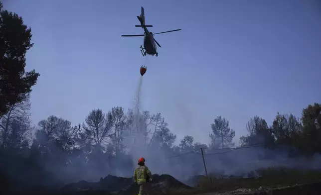 An Israeli fire crews member battles a wildfire in Latrun, Israel, outside of Jerusalem Thursday, May 1, 2025. (AP Photo/Ohad Zwigenberg)