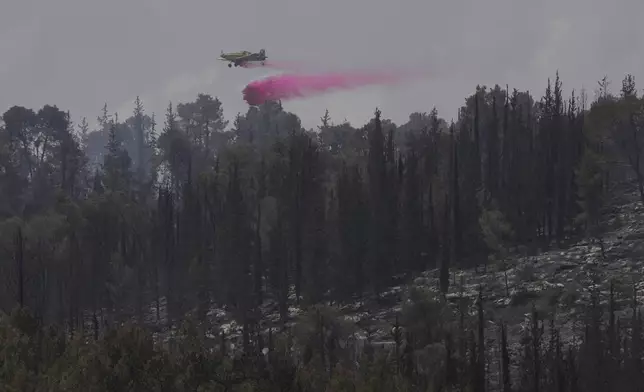An Israeli aircraft drops fire retardant on a wildfire in Latrun, Israel, outside of Jerusalem, Thursday, May 1, 2025. (AP Photo/Ohad Zwigenberg)