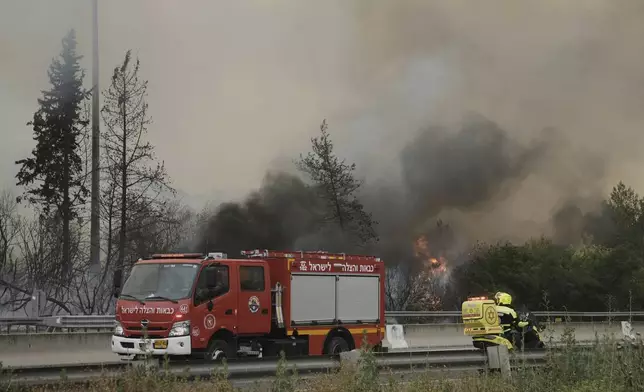 Firefighters work to extinguish a forest fire burning on a freeway to Jerusalem, Wednesday, April 30, 2025. (AP Photo/Mahmoud Illean)