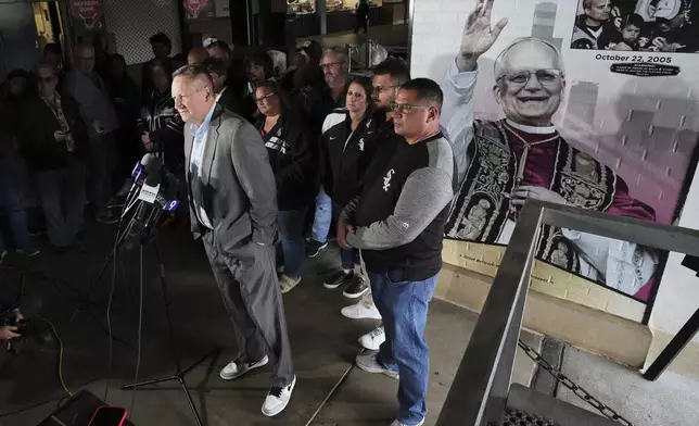 Brooks Boyer, left, Chicago White Sox Senior Vice President, Chief Revenue and Marketing Officer talks to media at a news conference for Chicago White Sox commemorate fandom of Pope Leo XIV with Graphic installation at Rate Field before a baseball game between the Seattle Mariners and the Chicago White Sox in Chicago, Monday, May 19, 2025. (AP Photo/Nam Y. Huh)