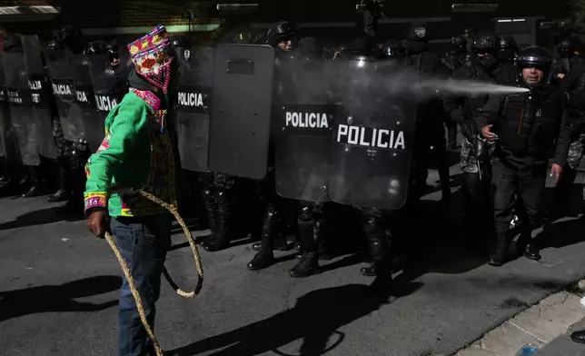 A supporter of former President Evo Morales confronts police during clashes near the offices of the Electoral Tribunal in La Paz, Bolivia, Friday, May 16, 2025. (AP Photo/Juan Karita)