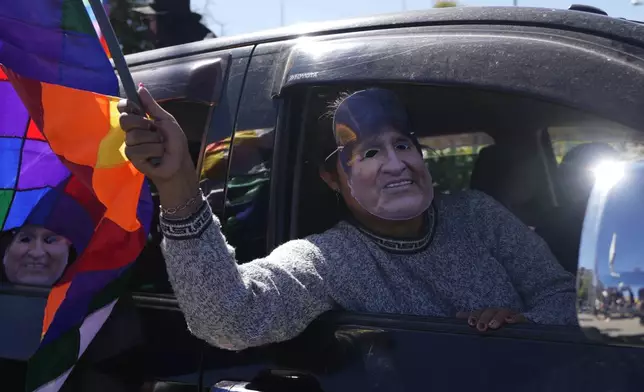 A man wearing a mask depicting former President Evo Morales tales part in a caravan to the Electoral Tribunal offices in El Alto, Bolivia, Friday, May 16, 2025. (AP Photo/Juan Karita)