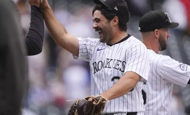 Colorado Rockies relief pitcher Zach Agnos is congratulated after a baseball game against the Atlanta Braves Wednesday, April 30, 2025, in Denver. (AP Photo/David Zalubowski)
