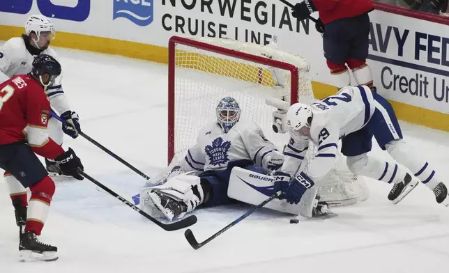 Toronto Maple Leafs goaltender Joseph Woll (60) stops a shot on goal during overtime in Game 3 of a second-round NHL hockey playoff series against the Florida Panthers, Friday, May 9, 2025, in Sunrise, Fla. (AP Photo/Marta Lavandier)