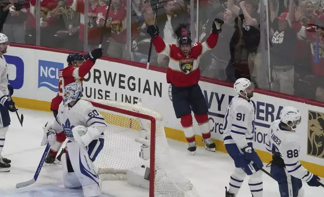 Florida Panthers center Carter Verhaeghe (23) celebrates after Brad Marchand (63) scored the winning goal in overtime in Game 3 of a second-round NHL hockey playoff series against the Toronto Maple Leafs, Friday, May 9, 2025, in Sunrise, Fla. (AP Photo/Marta Lavandier)