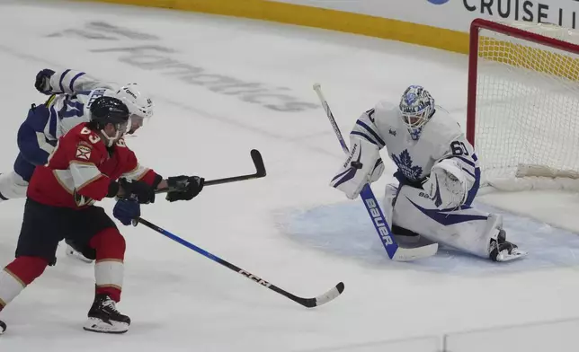 Toronto Maple Leafs goaltender Joseph Woll (60) deflects a shot on goal by Florida Panthers center Brad Marchand (63) during the second period in Game 3 of a second-round NHL hockey playoff series, Friday, May 9, 2025, in Sunrise, Fla. (AP Photo/Marta Lavandier)