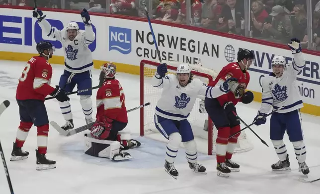 Toronto Maple Leafs players celebrate a goal by defenseman Morgan Rielly during the third period in Game 3 of a second-round NHL hockey playoff series against the Florida Panthers, Friday, May 9, 2025, in Sunrise, Fla. (AP Photo/Marta Lavandier)
