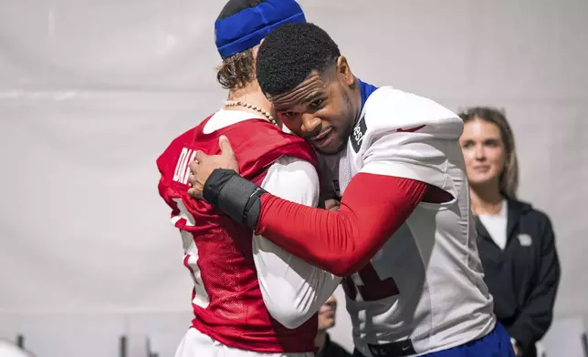 Rookie New York Giants linebacker Abdul Carter (51) and quarterback Jaxson Dart (6) embrace after their first day of the NFL football team's rookie minicamp, Friday, May 9, 2025, in East Rutherford, N.J. (AP Photo/Angelina Katsanis)