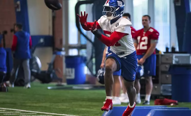 New York Giants linebacker Abdul Carter (51) catches a football during the NFL football team's rookie minicamp, Friday, May 9, 2025, in East Rutherford, N.J. (AP Photo/Angelina Katsanis)