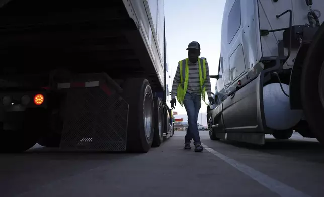 Haitian immigrant Kevenson Jean, a truck driver, checks his truck before a road trip, Tuesday, April 15, 2025, in Panhandle, Texas. (AP Photo/Eric Gay)