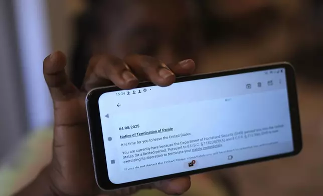 Nicole, a Haitian immigrant who works for a meat processing plant, shows an email terminating her parole, Sunday, April 13, 2025, in Dumas, Texas. (AP Photo/Eric Gay)