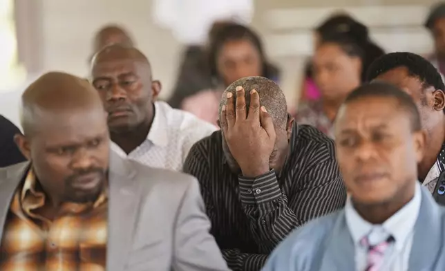 Haitian immigrants gather at a park following a church service where they shared pizza and sought out answers about their legal status, Sunday, April 13, 2025, in Dumas, Texas. (AP Photo/Eric Gay)