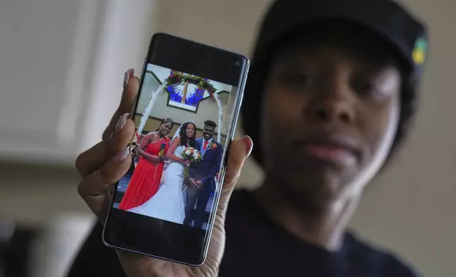 Haitian immigrant Sherlie Jean, a fast food worker, shows photos from her U.S. wedding to Kevenson Jean, a truck driver, Wednesday, April 16, 2025, in Panhandle, Texas. (AP Photo/Eric Gay)