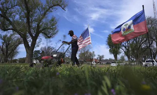 Haitian immigrant Kevenson Jean mows his yard, Monday, April 14, 2025, in Panhandle, Texas. (AP Photo/Eric Gay)
