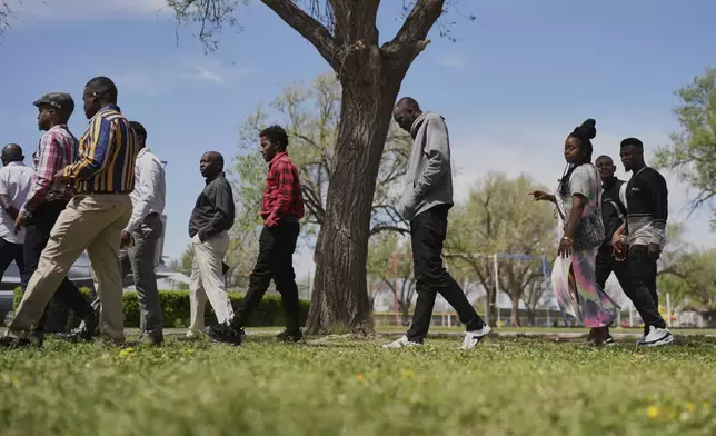 Haitian immigrants walk through the park following a church service, Sunday, April 13, 2025, in Dumas, Texas. (AP Photo/Eric Gay)